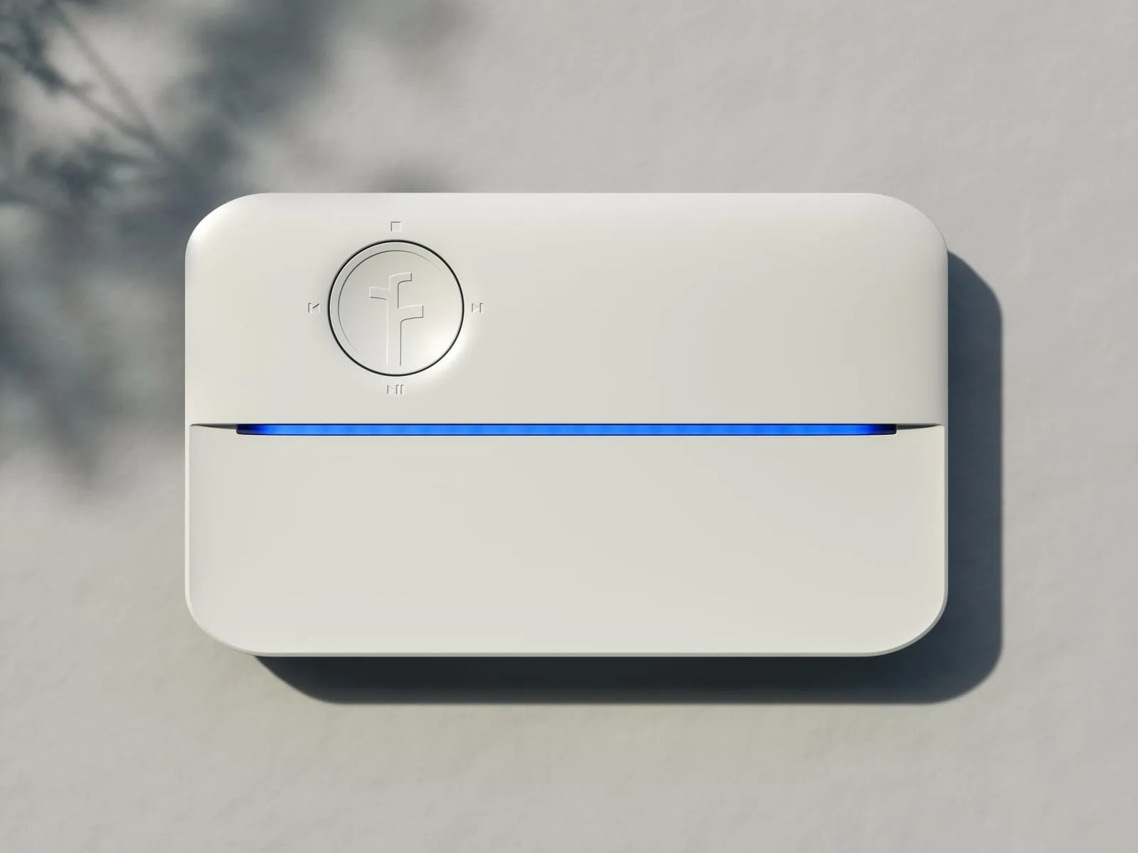 Rachio 3 smart sprinkler controller mounted on a stucco wall