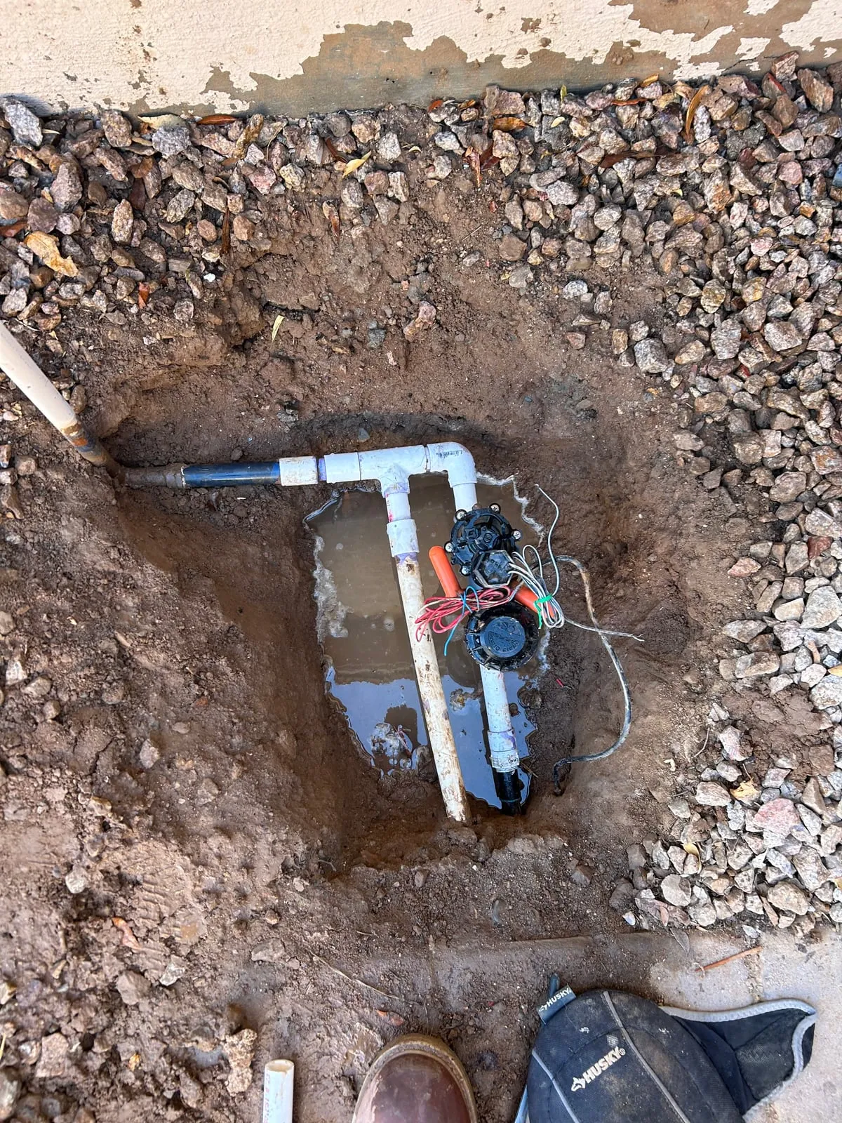 Irrigation valve exposed in a dug-out valve box during repair
